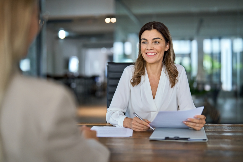 Recruitment professional meeting with a job candidate to discuss opportunities through digital marketing for recruitment.
