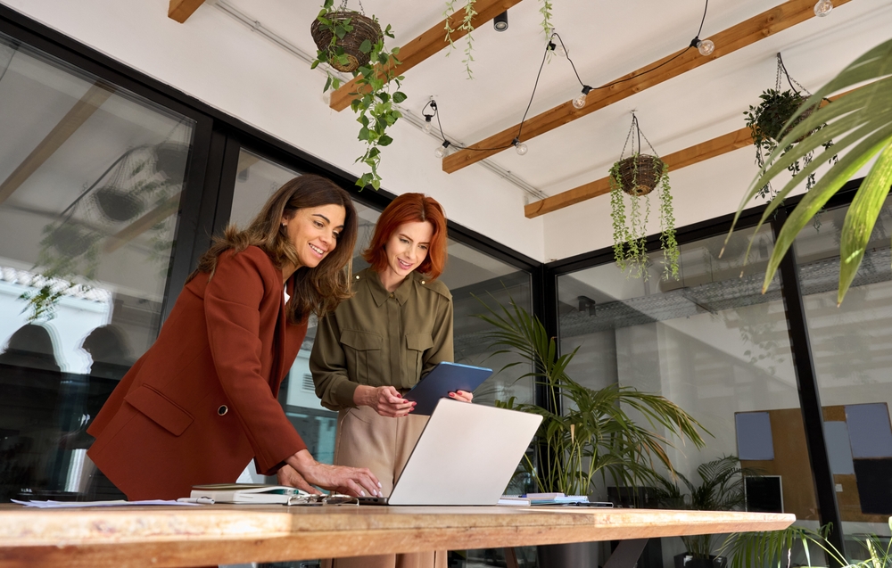 Two professionals reviewing EVP messaging on a laptop while planning an employee advocacy program
